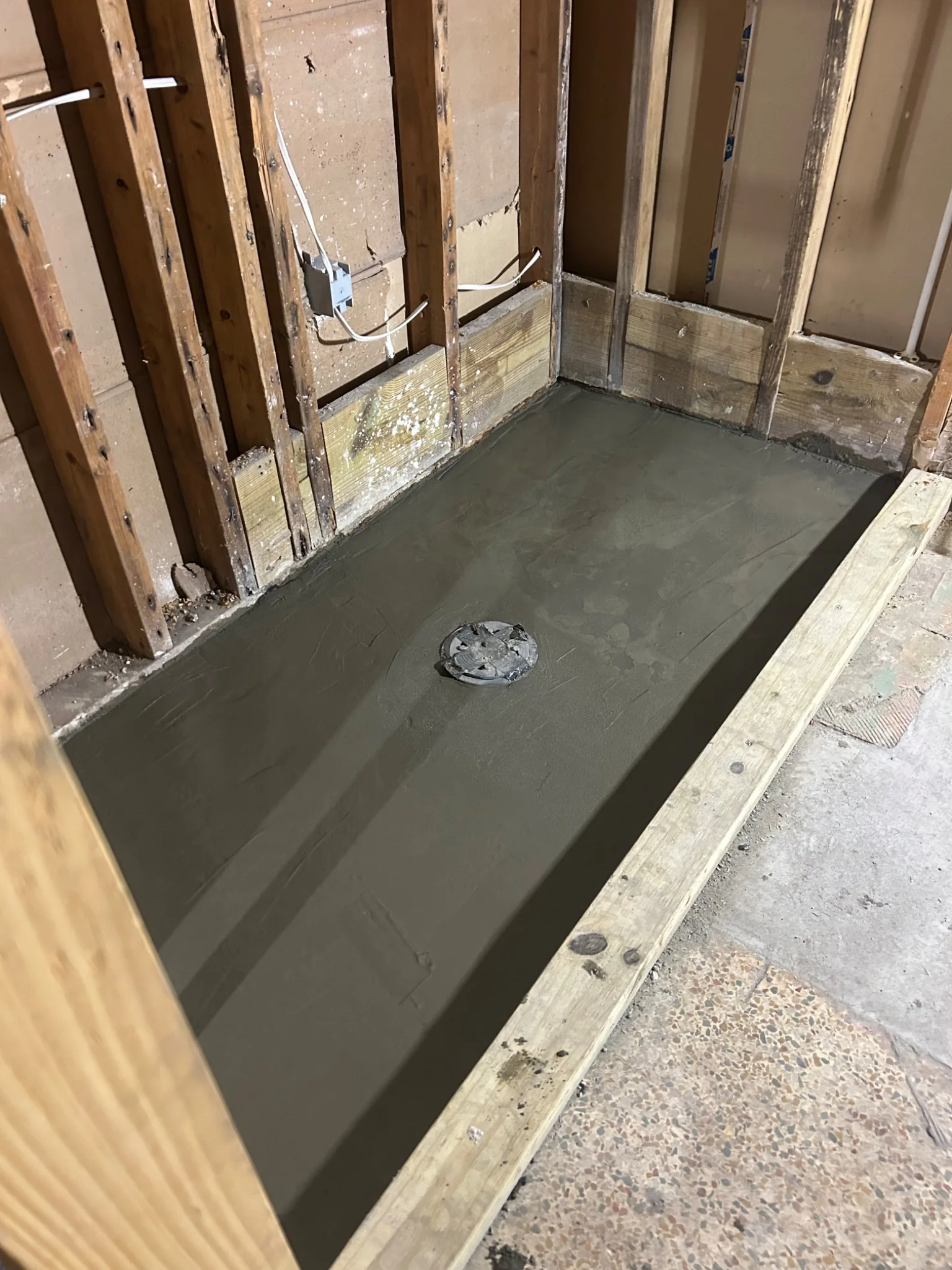 Shower pan under construction with exposed framing
